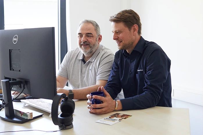 DrachenGas-Mitarbeiter zeigt einem Kunden Informationen am Computer