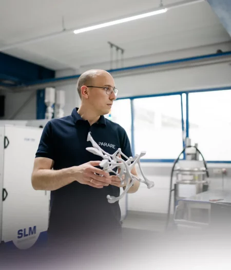 Ingenieur hält ein komplexes 3D-gedrucktes Metallbauteil