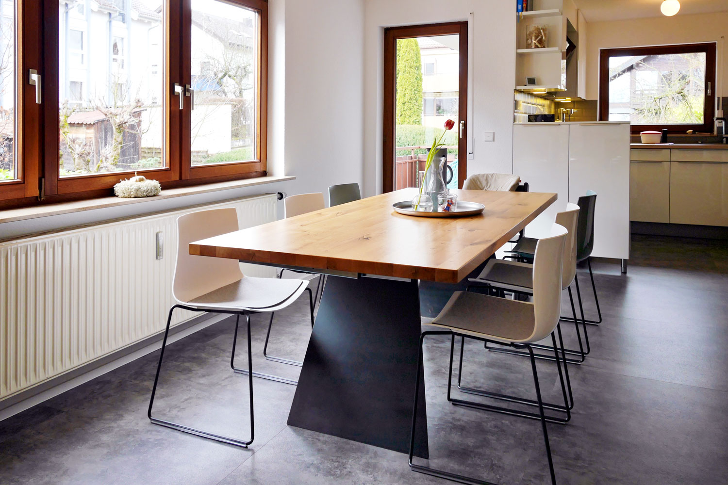 Esszimmer mit Esstisch aus Holzplatte und schwarzen Metallgestellen