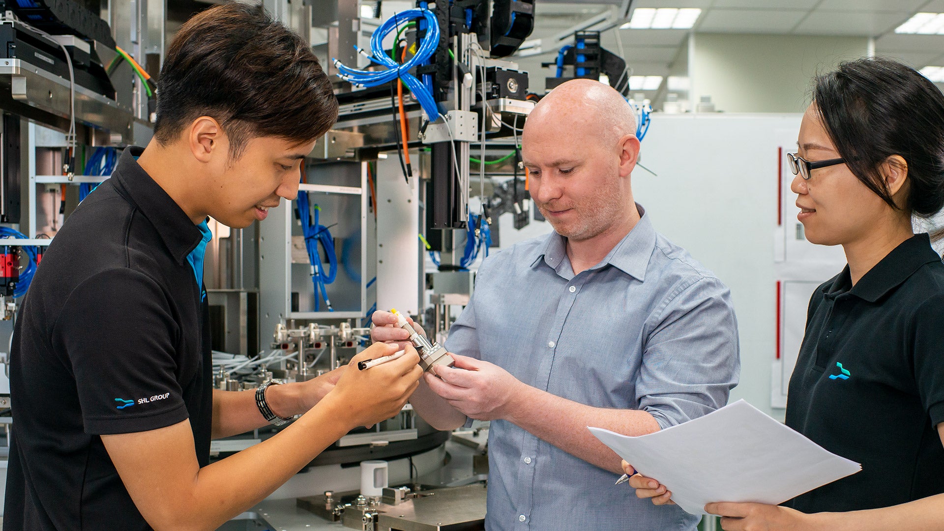 Projektingenieure prüfen ein Autoinjector-Bauteil vor einer vollautomatischen
