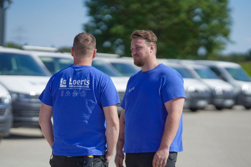 Team vor den Firmenfahrzeugen