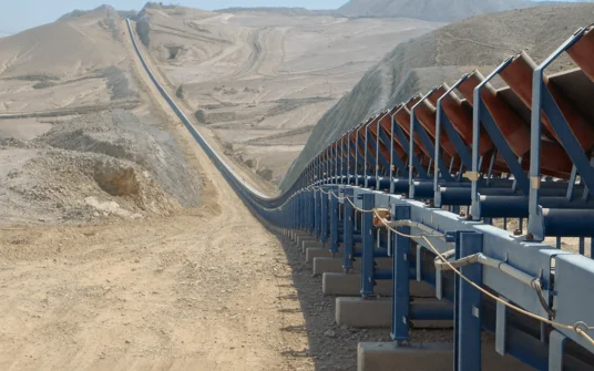 Overland trough belt conveyor in einer Wüsten-Minenlandschaft