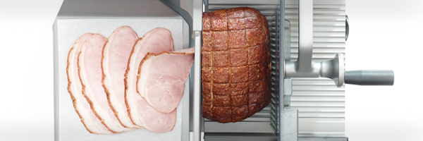 Frisch aufgeschnittener Krustenbraten auf automatischer Schneidemaschine