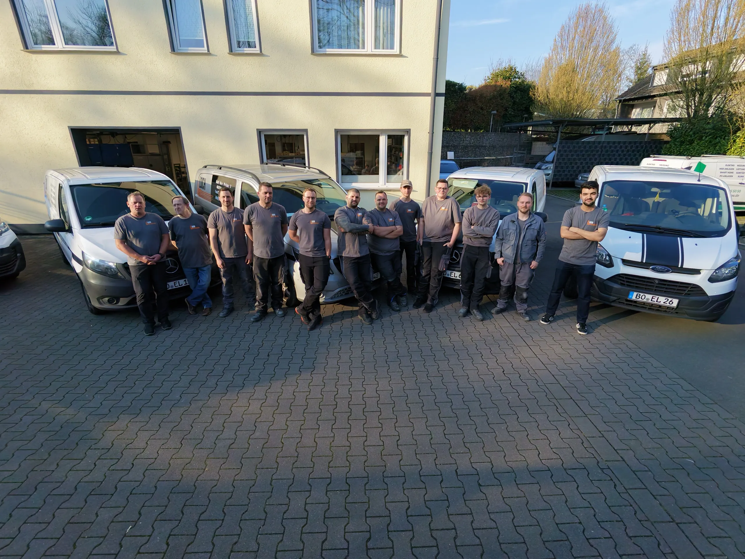 Das Team der Elektro Loch GmbH vor den Servicefahrzeugen am Standort Auf der
