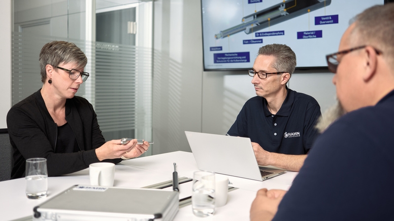 Mitarbeitende besprechen eine Gasdruckfeder