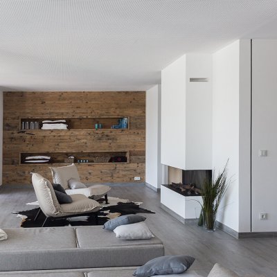 Entspannungsbereich mit holzverkleideter Akzentwand und Kamin