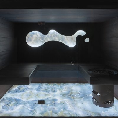 Designsauna mit hinterleuchtetem Vetrite-Boden und grauer Glasfront