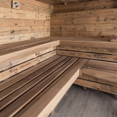 Rustikale Sauna aus Altholz mit Thermoholz-Bänken