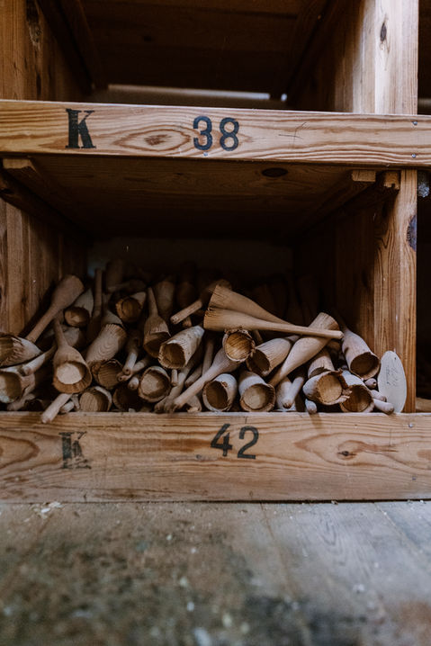 Alte Pinselstiele in nummerierten Holzkisten