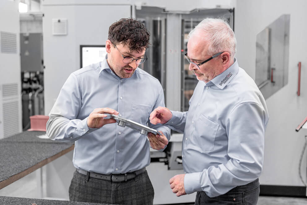 Geschäftsführung im Gespräch über ein Bauteil