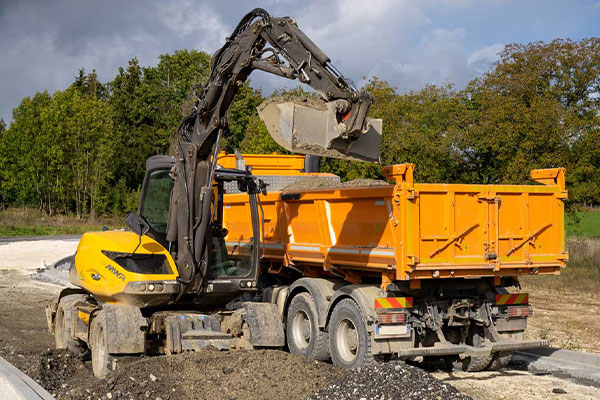 Bagger beim Erdaushub mit Muldenkipper