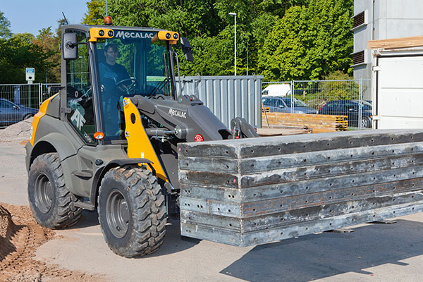 Mecalac-Maschine beim Be- und Entladen von Metallplatten