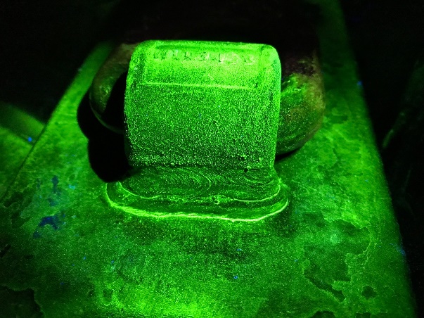 Fluoreszierende Magnetpulverprüfung an einem Hebeauge