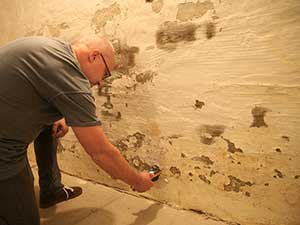 Sachverständiger bei der ATG Schadensanalyse an feuchter Kellerwand