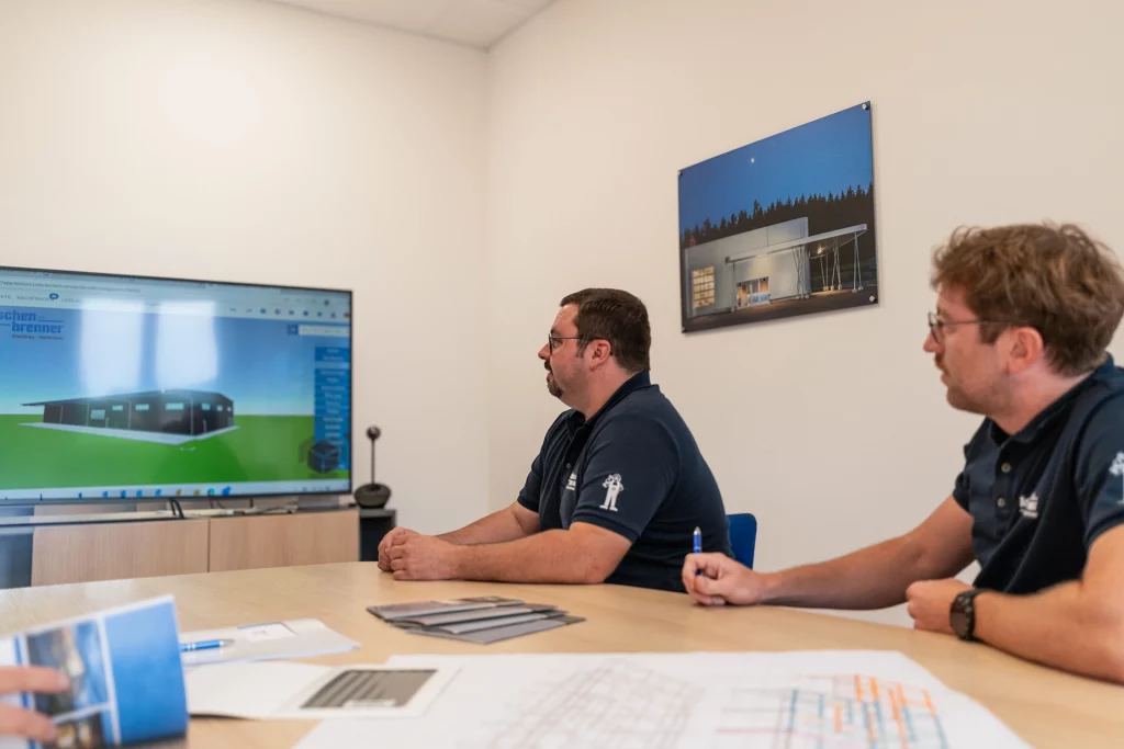 Mitarbeiter analysieren eine geplante Stahlhalle im Hallenkonfigurator