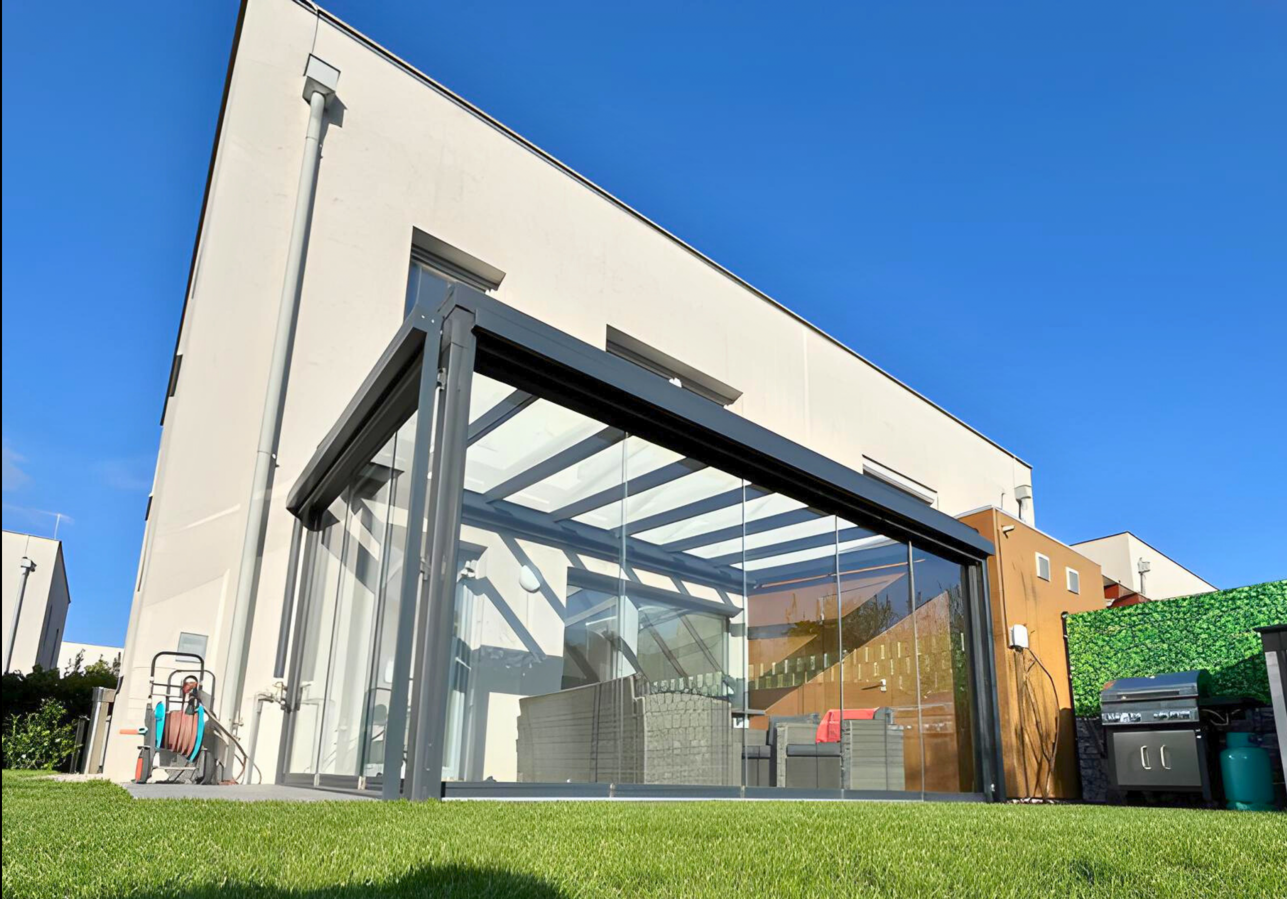 Terrassenüberdachung aus Glas und Aluminium als Erweiterung des Wohnraums