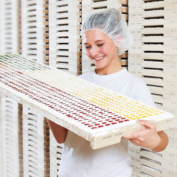 Mitarbeiterin prüft fertige Fruchtgummi-Figuren