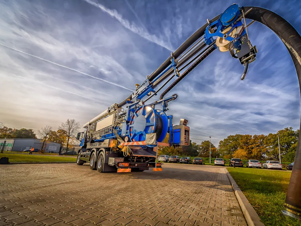 Saug-Spülfahrzeug mit Saugausleger vor dem Werk