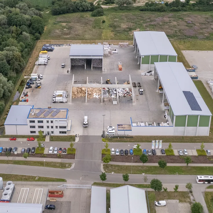 Luftaufnahme eines Kühl-Betriebshofs mit Hallen, Sortierflächen und Fuhrpark