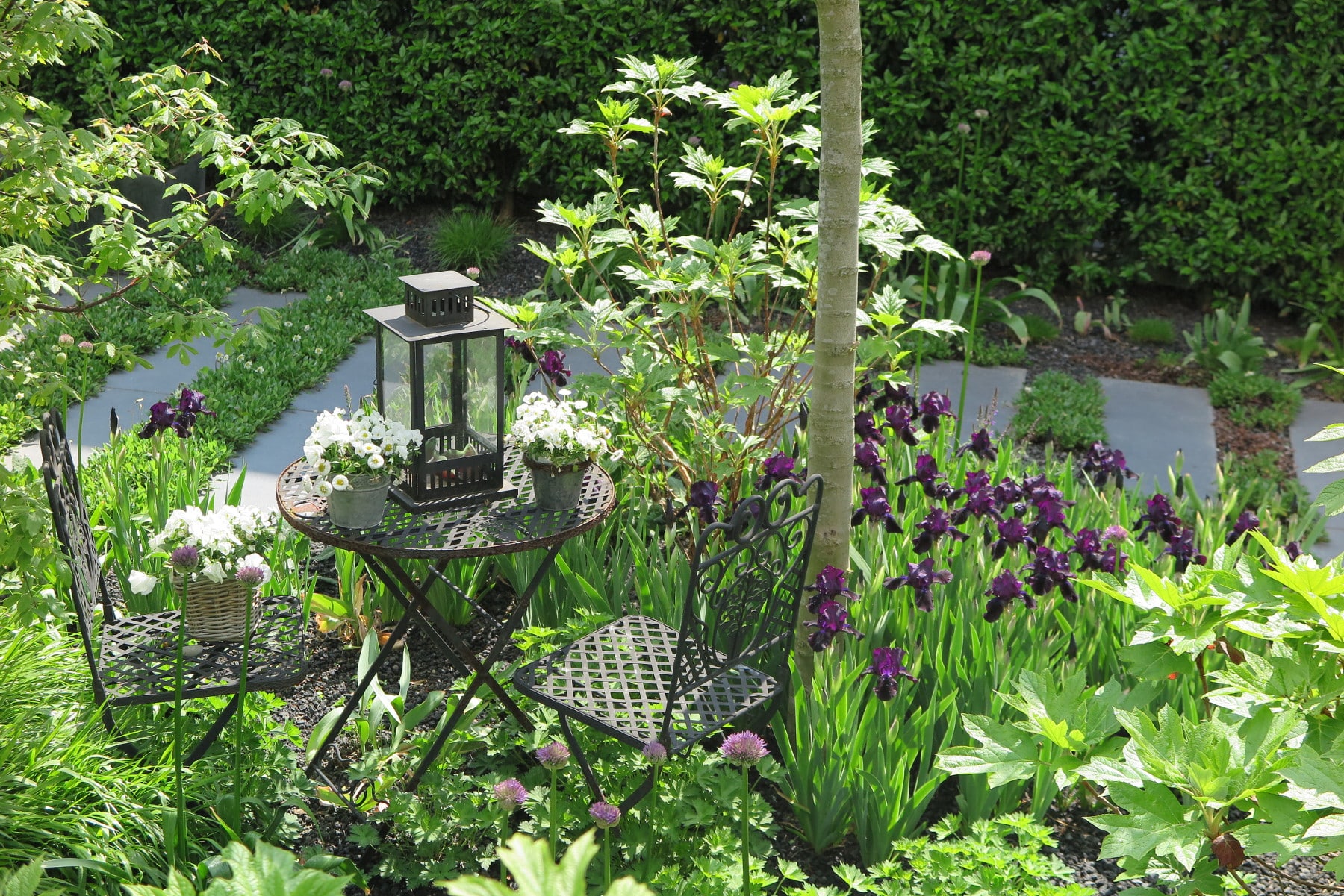 Gartensitzplatz mit Möblierung und Blütenpflanzung